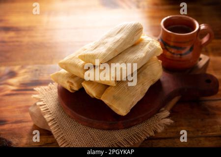 Tamales. Piatto prehispanico tipico del Messico e di alcuni paesi dell'America Latina. Pasta di mais avvolta in foglie di mais. I tamales vengono cotti al vapore. Foto Stock