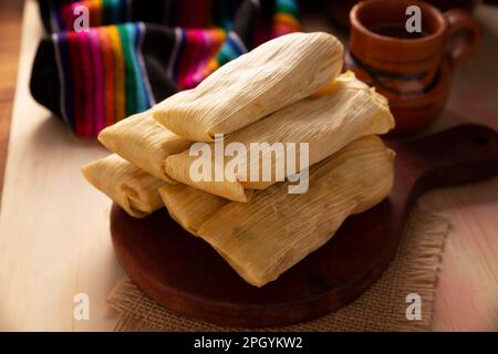 Tamales. Piatto prehispanico tipico del Messico e di alcuni paesi dell'America Latina. Pasta di mais avvolta in foglie di mais. I tamales vengono cotti al vapore. Foto Stock