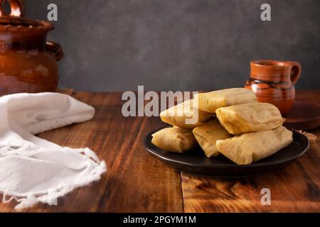 Tamales. Piatto prehispanico tipico del Messico e di alcuni paesi dell'America Latina. Pasta di mais avvolta in foglie di mais. I tamales vengono cotti al vapore. Foto Stock