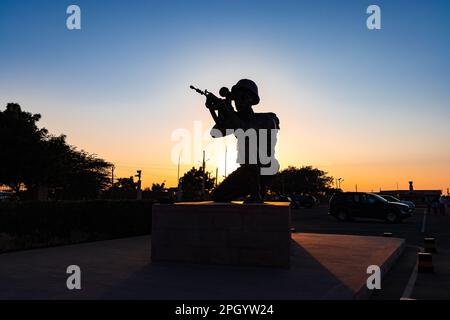 soldato isolato retro illuminato statua con pistola e cielo drammatico da diverse angolazioni alla sera Foto Stock