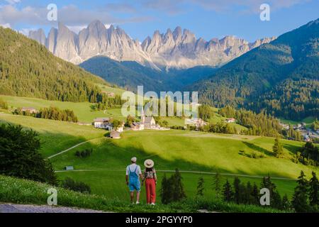 Coppia a St. Magdalena Geisler o Odle Dolomiti cime montane. Val di Funes in Italia, Santa Magdalena villaggio Dolomiti montagne, uomini e donne in vacanza nelle Alpi di montagna italiane Foto Stock