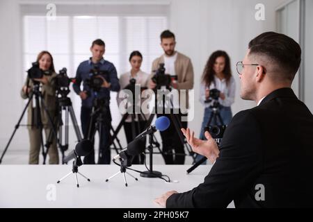 Uomo d'affari che dà intervista ai giornalisti durante l'evento ufficiale Foto Stock