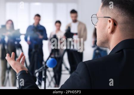 Uomo d'affari che dà intervista ai giornalisti alla manifestazione ufficiale, closeup Foto Stock