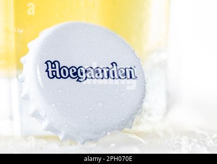 LONDRA, Regno Unito - 15 DICEMBRE 2022: Berretto della bottiglia di birra di grano Hoegaarden con rugiada su bianco con vetro. Foto Stock