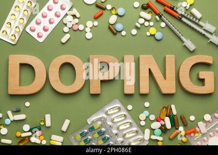 Composizione piatta con doping di parola e farmaci su sfondo verde Foto Stock