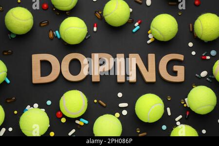 Composizione piatta con doping parola, palle da tennis e droghe su sfondo nero Foto Stock