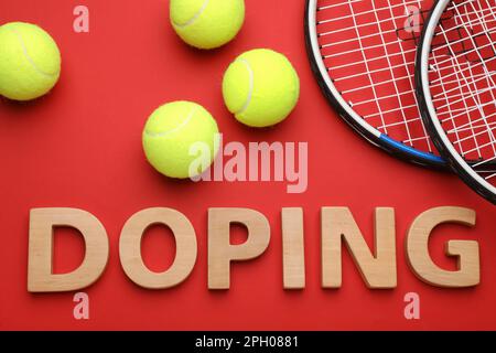 Composizione piatta con doping parola, palle da tennis e racchette su sfondo rosso Foto Stock