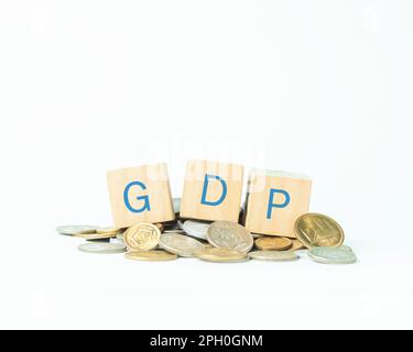 Parola GDP scritto su blocchi di giocattoli e monete sul tavolo con sfondo bianco Foto Stock