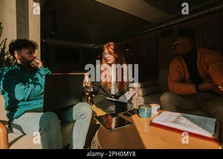 Giovani uomini d'affari multirazziali fare un affare sul progetto in un bar in una bella mattinata di sole Foto Stock