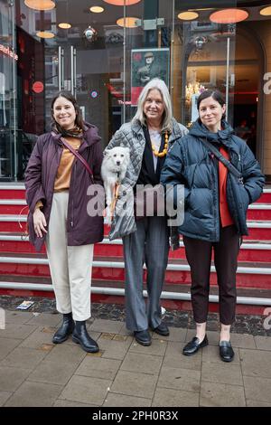 Amburgo, Germania. 25th Mar, 2023. Natascha Giller (m) con il cane Coco e le sue figlie Tatiany (l) e Alexia Stamatelatos stand di fronte al teatro Hamburger Kammerspiele. La proprietà della coppia di attori Nadja Tiller e Walter Giller è stata venduta a beneficio di Amburgo Leuchtfeuer. Credit: Georg Wendt/dpa/Alamy Live News Foto Stock