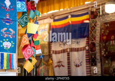 Bandiere di preghiera bhutan bhuddist colorate montate sul negozio che danno una visione comune attraverso le stazioni collinari in India e un acquisto turistico comune Foto Stock