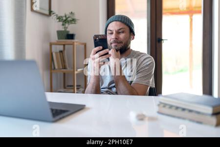 L'uomo adulto usa la rete wireless a casa guardando le bobine nei social media. Foto Stock