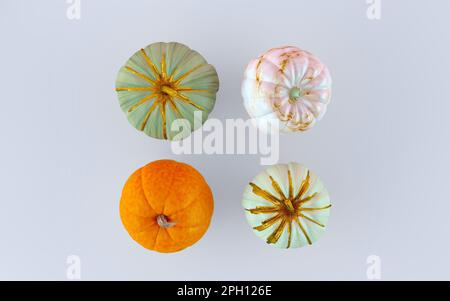 Quattro zucche per la vista dall'alto di Halloween. Diverse zucche decorate con oro su sfondo bianco con spazio copia. Modello autunnale festivo Foto Stock