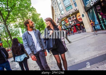 05-14-2016 Parigi, Francia. Parision giovane coppia innamorata: Sorridendo e camminando sulla strada Champ-Elysees nel mese di maggio Foto Stock