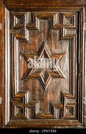 Particolare di un lavoro su una porta in legno con una stella a sei punte (stella di David) al centro Foto Stock