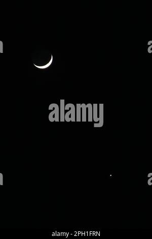 Luna crescente e Venere nel cielo nero della sera il 24 marzo 2023 Foto Stock