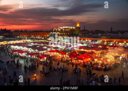 Bancarelle di cibo al tramonto sulla piazza Djemaa El Fna. La sera la grande piazza si riempie di bancarelle di cibo, attirando folle di locali e turisti. M Foto Stock