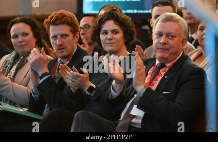 (Secondo da sinistra a destra) Matthew o'Toole, Claire Hanna MP e Patsy McGlone MLA applaudono come leader dell'SDLP Colum Eastwood (non illustrato) parla durante la conferenza di primavera del Partito socialdemocratico e laburista (SDLP) a St Columb's Hall a Derry. Data immagine: Sabato 25 marzo 2023. Foto Stock