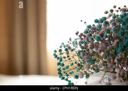 Bel bouquet con fiori freschi sul tavolo in camera da letto. Spazio per il testo. Vaso con bei piccoli fiori blu sulla scrivania contro la luce finestra backgrou Foto Stock