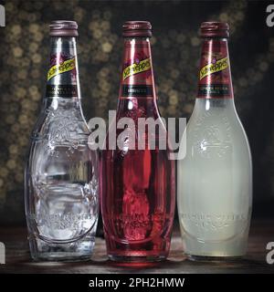 Koszalin, Polonia, 25 marzo 2023. Bottiglia di vetro Schweppes su sfondo astratto. Logo Schweppes. Foto di bottiglie con diversi sapori di Schwepp Foto Stock