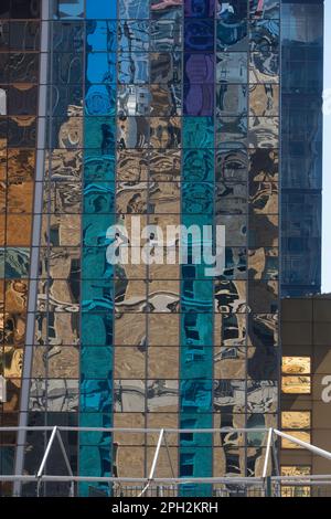 Riflesso astratto l'alto grattacielo si riflette nelle finestre di un edificio adiacente Foto Stock