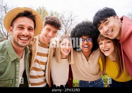 Grande gruppo di giovani amici allegri che scattano un ritratto di selfie. Persone felici che si abbracciano l'un l'altro. Foto Stock