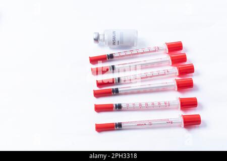 Siringa per uso medico con fiale di vetro su sfondo bianco. Foto Stock