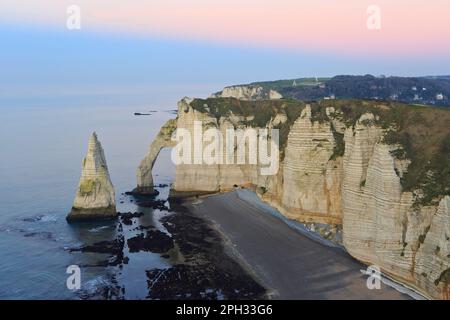 La Porte d'Aval (arco) e la formazione appuntita noto come l'ago (l'Aiguille) a Etretat (Senna Marittima), Normandia, Francia al crepuscolo Foto Stock