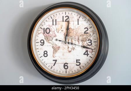 Vecchio orologio con lancette delle ore e dei minuti con quadrante della mappa del mondo Foto Stock