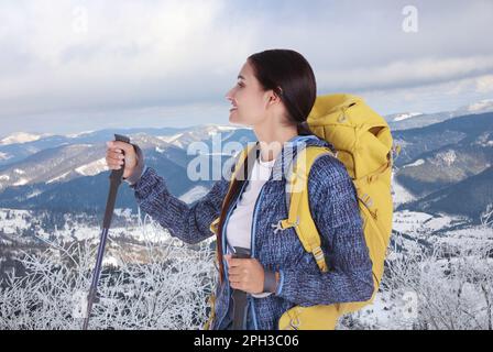 Donna con zaino e racchette da trekking in montagne innevate Foto Stock