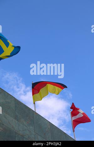 La bandiera tedesca che sventolava in cima all'edificio con altre bandiere delle Nazioni Foto Stock