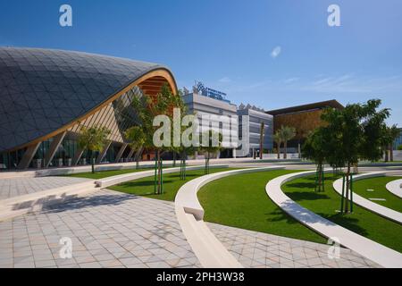 Spazio verde, prato, parco con moschea, biblioteca e centro multiuso. A Masdar City, una comunità prepianificata, verde, sostenibile e consapevole del cambiamento climatico. IO Foto Stock