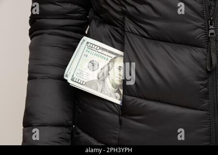 Cento dollari nella tasca delle ragazze giacca nera, soldi Foto Stock