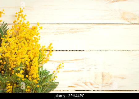 Mimosa fiori bouquet sullo sfondo rustico bianco legno. Decorazioni in stile elegante e shabby. Messa a fuoco selettiva. Spazio per il testo. Vintage in tonalità retrò Foto Stock