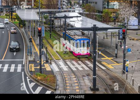 21 marzo 2023: Treno di Kumamoto City Tram fermata di fronte alla stazione ferroviaria di Kumamoto a Kyushu, Giappone. Ci sono cinque linee nel conteggio ufficiale, bu Foto Stock