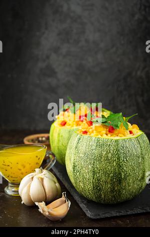 Zucchine farcite con riso e verdure su un tavolo scuro. Vista laterale. Spazio di copia. Foto Stock