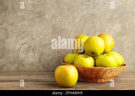 Mele verdi nel cesto su sfondo grigio in legno, vista dall'alto Foto Stock