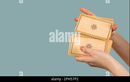 Le mani si mescolano, randomizzando le carte tarocchi sul banner, sfondo blu. Foto Stock