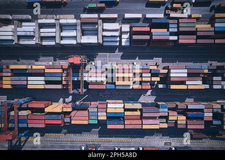 Vista aerea dall'alto verso il basso dei contenitori di carico impilati. Container presso il terminal logistico. Magazzino esterno per container da carico Foto Stock