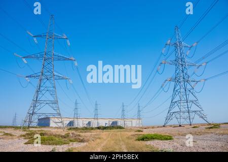 Piloni che trasportano elettricità dalla sottostazione della centrale nucleare di Dungeness B, Dungeness, Kent, Regno Unito Foto Stock