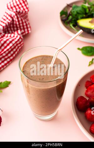 Colazioni salutari, frullati a base di fragole congelate, avocado e banana, proteina di piselli e semi di lino, foglie di insalata, frullati i Foto Stock