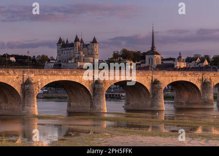 Vista sul fiume Loira durante l'alba con il vecchio ponte, il castello e la chiesa di Saumur, Francia. Foto Stock