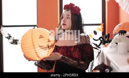 Giovane donna bionda che indossa il costume di katrina che tiene la lampada di zucca di Halloween nel paese Foto Stock