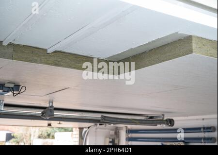 Pannelli isolanti in lana minerale, incollati sotto un soffitto del seminterrato Foto Stock