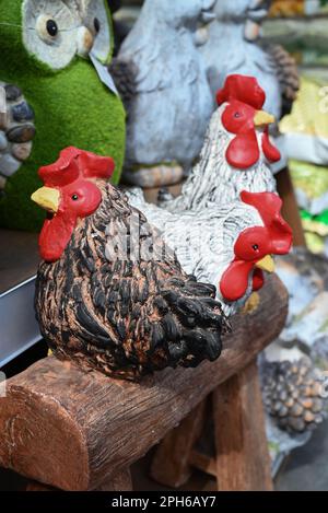 Figurina di argilla di un pollo su sfondi diversi. Pollo bianco di argilla fatto a mano. Il concetto di arte, giocattoli decorativi, scultura. Foto Stock