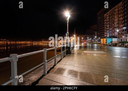 Strade vuote accanto al lungomare di Gijon di notte in un giorno piovoso, Asturie. Foto Stock