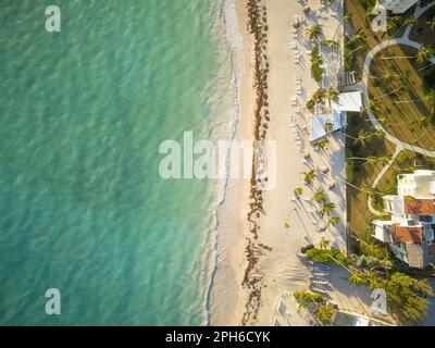 Bellissima spiaggia di mare. Riprese da un drone. Mare smeraldo limpido. Sulla spiaggia ci sono alberghi, bungalow tra palme. Percorso a piedi ben tenuto Foto Stock