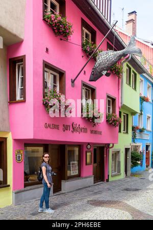 Lindau, Germania - 19 luglio 2019: Strada con case colorate nel centro storico di Lindau, donna turistica passeggiate lungo vicolo passato ristorante di pesce in estate. Loro Foto Stock