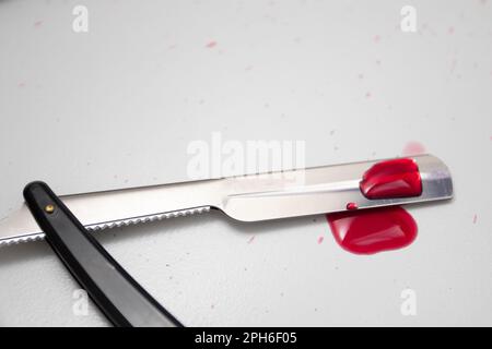 Gocce di sangue su un rasoio dritto Foto Stock