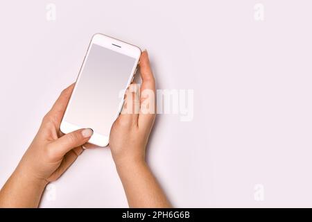 Le mani femminili che tengono un cellulare moderno. Foto Stock